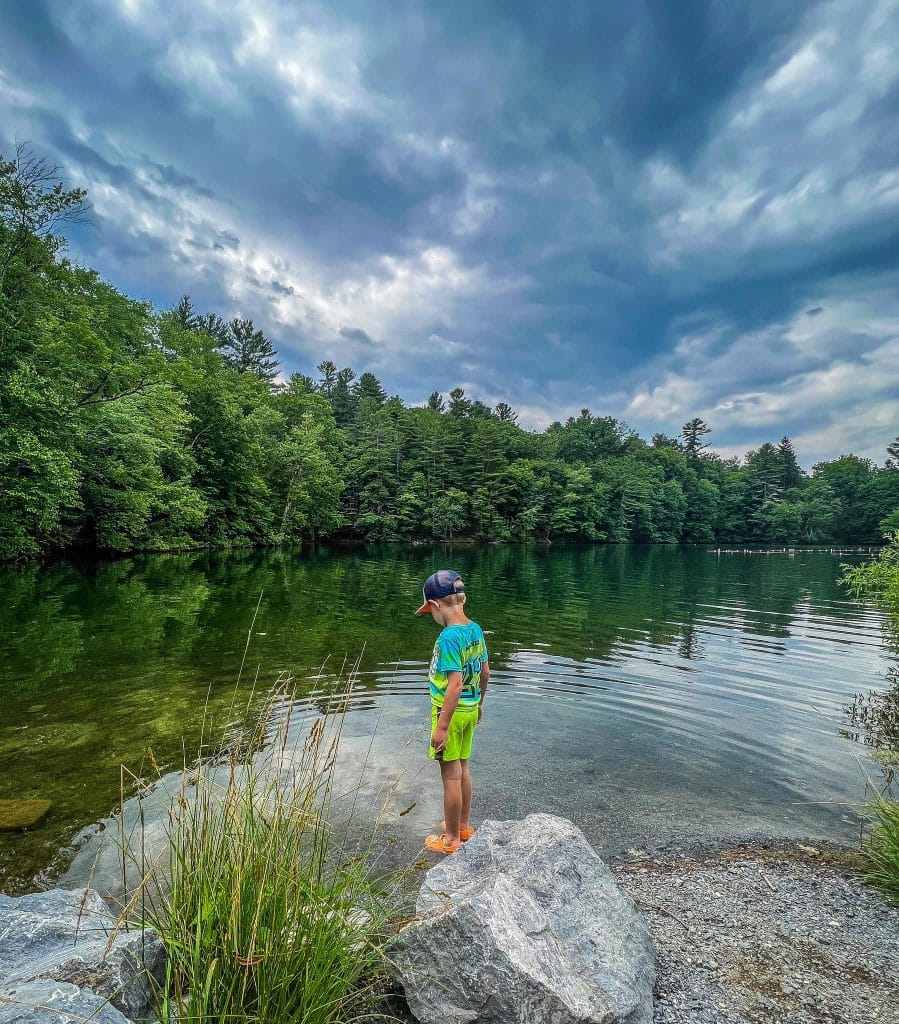 Lake with boy standing near rocks
